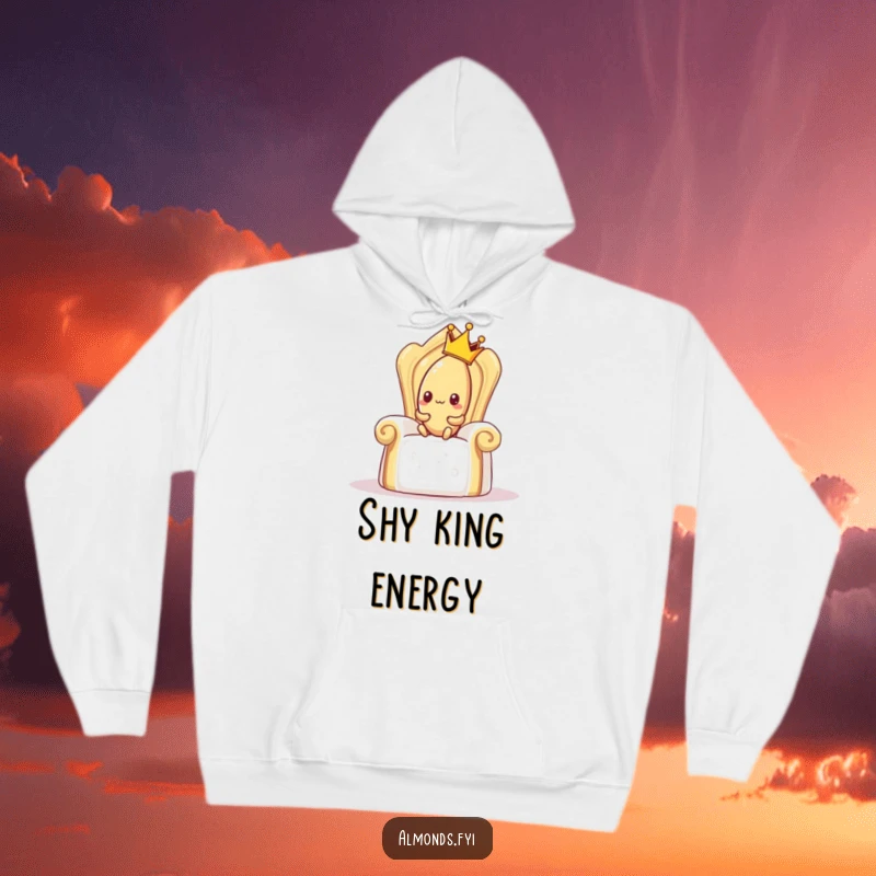 Funny hoodie depicting a shy almond wearing a crown, awkwardly trying to sit on a giant sugar cube throne, cozy and humorous apparel.